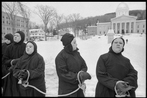 Protesters from Bread and Puppet Theater, hands bound and dressed in cloaks and masks, during a demonstration against the invasion of Laos at the Vermont State House