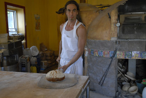 Hungry Ghost Bread: owner and baker Jonathan C. Stevens removing loaves of bread from the oven