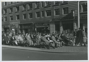 People sitting on benches at the intersection of West 86th Street and Broadway in New York City