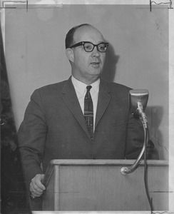 Dean Edward C. Moore speaking at a microphone