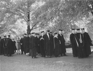 Men in academic gowns gather for commencement exercises