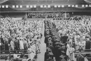 Graduates in a Commencement procession through Curry Hicks Cage