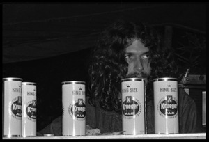 Man sitting behind beer cans as the band plays, Earth People's Park
