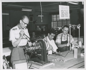 Three men at work in the leather goods manufacturing workshop