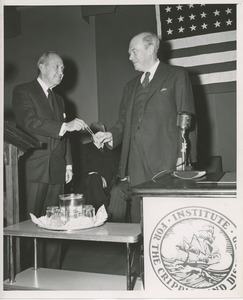 Jeremiah Milbank Sr. handing a pen to ICD vice president Richard C. Hunt at the Columbia University and Presbyterian Hospital affiliation ceremony