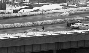 Police officer walking among cars on snowy highway in Boston