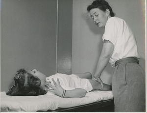 Betty Ann Feinstein examining a young girl with cerebral palsy