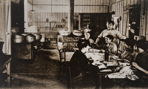 Group of women sitting around a table in a canteen kitchen