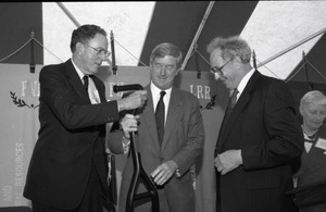 Ceremonial groundbreaking for the Conte Center: Gov. William Weld receiving ceremonial shovel from UMass Amherst Provost Richard O'Brien; unidentified man at far left