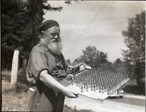 Charles Coffin, The Maine Hermit, holding folk-art sculpture of soldiers on parade