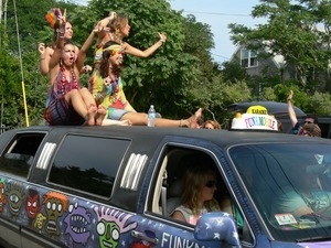 Parade marchers riding on top of the Karaoke Funkmobile : Provincetown Carnival parade