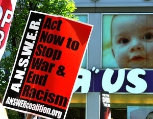 A.N.S.W.E.R. (Act Now to Stop War and End Racism) sign held up in front of a Toys R Us store and image of a baby