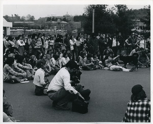 Board of Trustees fee increase demonstration: photographer with protestors, listening to speaker