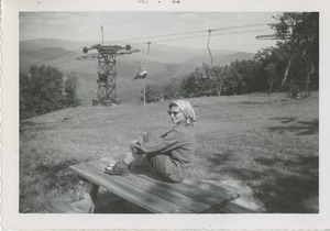 Bernice Kahn on picnic table in front of out of season ski lift
