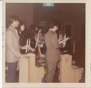 Group holding bibles in pew