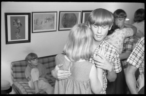 Teenage long hair: boys and girls at a teenage dance party as a young boy watches from the couch