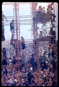 Concert goers seated on the scaffolding for the light towers, Woodstock Festival