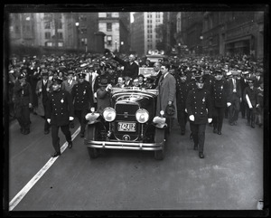 Gov. Alfred E. Smith waving to the crowd from the back of his automobile