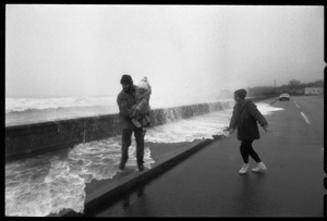 Judy Salonia, her husband Vincent, and daughter Ashley (4) watch a huge surge crashing over the Narragansett seawall