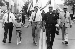 Mayor Raymond L. Flynn and his daughter Katie marching in the Bunker Hill Day Parade in Charlestown with James Conway, Metropolitan District Commission Officer Bill Connell and Ed Kelly