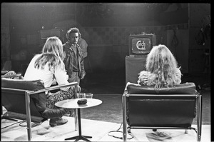 Commune members at the WGBY Catch 44 (public access television) interview: shot from the rear of Anne and Jim Baker on stage, looking at monitor showing Catch 44 opening logo