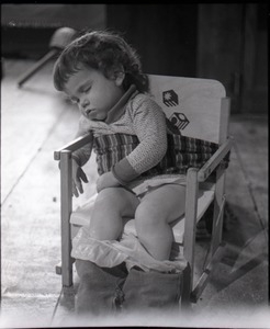 Child sleeping in a potty-training chair