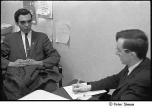 Raymond Mungo interviewing a man with two black eyes in the BU News office