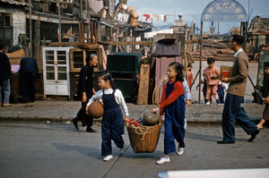 Two girls carry basket with balls