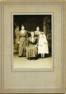 Women of the family with a daughter at first communion: full-length studio portrait