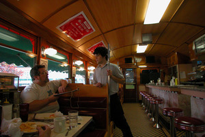 Waiter and diners in a booth, ordering food at the Miss Florence Diner