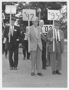 Charles Peters, Albert Parsons, and Ralph Drury holding class signs at 1954 reunion