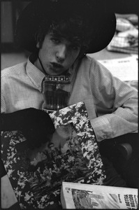 At the Boston University News Office: Peter Simon wearing hat and glove and holding a phone book and a copy of Rolling Stones', 'Their Satanic Majesties Request'