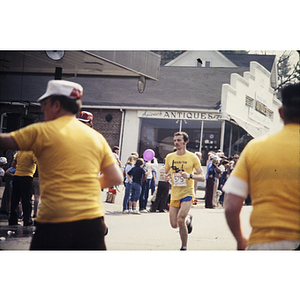 Runner passing YMCA staff at water station during Boston Athletic Association (BAA) marathon