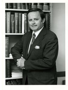 Suffolk University Dean John E. Fenton, Jr. (Law) in front of law book shelf
