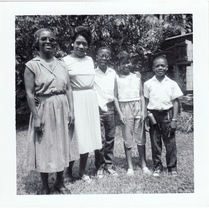 Inez Irving Hunter poses with a woman and her children in a back yard