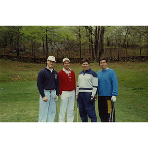 A four-man golf team posing on the golf course at a Boys & Girls Club Golf Tournament