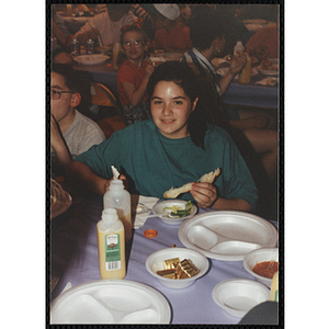 A girl smiles for the camera while holding a piece of bread at a Boys and Girls Club Awards Night