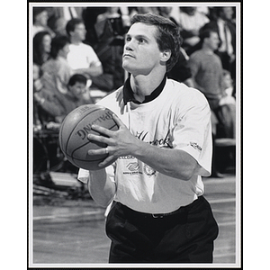 Former Boston College Eagle Gerard Phelan holding a basketball and looking up at a fund-raising event held by the Boys and Girls Clubs of Boston and Boston Celtics