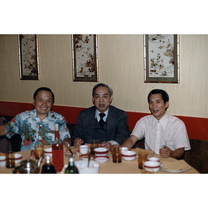 Three men at a restaurant table during Chinese Progressive Association's Third Anniversary Celebration