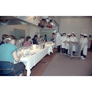 Chefs talk to judges seated at tables