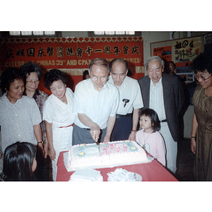 Henry Wong serves cake at the Chinese Progressive Association's 11th Anniversary