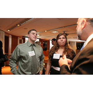 Joseph Bordieri and Nadia Alvarez converse with a man at a Torch Scholars event