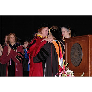 Patricia Kiladis, left, and Carole Kenner hug at School of Nursing convocation