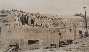 One Red Cross worker and three men standing on top of a concrete machine-gun bunker at La Laufée