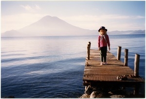 Maya Sommer on pier on Lago de Atitlán in San Marcos La Laguna, with volcano in the distance