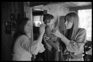 Joni Mitchell (right) and Judy Collins, playing with a Graham Nash doll at Mitchell's house in Laurel Canyon