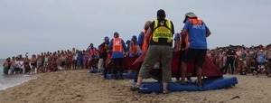 International Fund for Animal Welfare volunteers begin to lift dolphins off their mats to carry them to the water, with crowd looking on