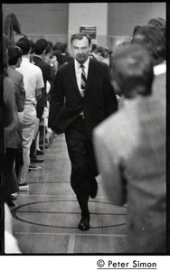 Man leading the entourage of presidential candidate Eugene J. McCarthy up an aisle before a speech at Boston University