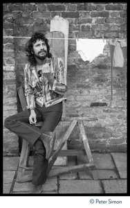 Cat Stevens: full-length portrait, seated by a laundry line on Carly Simon's patio