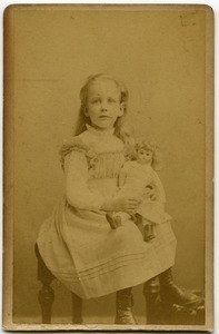 Alice Channing: studio portrait as a young girl, seated with doll